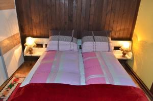 a bed with two pillows and a wooden headboard at Villa San in Zlatibor