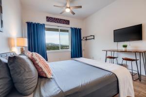 a bedroom with a bed and a tv and a window at Unit 12 Maui Ohana Modern Studio in Wailuku