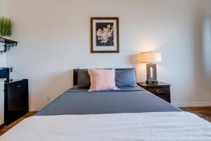 a bedroom with a large bed with a blue blanket at Unit 12 Maui Ohana Modern Studio in Wailuku