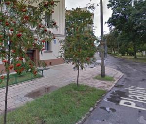 uma árvore ao lado de uma rua ao lado de um edifício em Piękny apartament przy parku, blisko dworca, centrum Radom em Radom