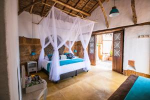 a bedroom with a bed with a mosquito net at Hotel Boutique Venturi in Barichara