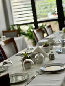 einen Tisch mit weißen Tellern und Gläsern darauf in der Unterkunft Hotel Mimani in Berat