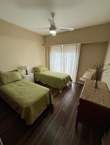 1 dormitorio con 2 camas y ventilador de techo en Departamento en Ramallo en Ramallo