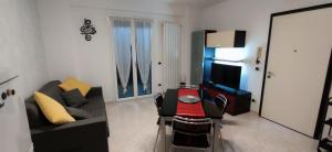 a living room with a couch and a table and a television at Casa Francesca: un mare di relax! in Ventimiglia