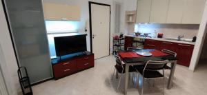a kitchen with a table with chairs and a television at Casa Francesca: un mare di relax! in Ventimiglia