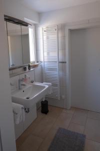 a white bathroom with a sink and a mirror at Top Wohnung mit traumhaftem Fernblick in 1A-Lage! in Hagen