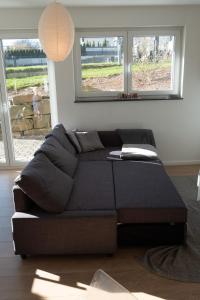a black couch in a living room with windows at Top Wohnung mit traumhaftem Fernblick in 1A-Lage! in Hagen