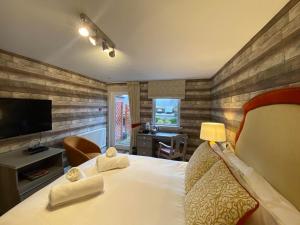 a hotel room with a bed and a television at Achray House Restaurant with Rooms in Saint Fillans