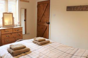a bedroom with a bed with two towels on it at The Retreat in Niton