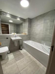y baño con bañera, aseo y lavamanos. en Achray House Restaurant with Rooms en Saint Fillans