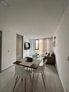 een woonkamer met een tafel en stoelen en een bank bij Elegante apartamento in Cartago