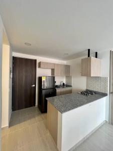 La cuisine est équipée d'un comptoir et d'un réfrigérateur. dans l'établissement Elegante apartamento, à Cartago