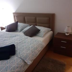 um quarto com uma cama e uma mesa de cabeceira com um candeeiro em Mabela em Virovitica