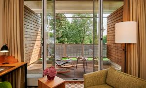 a room with a balcony with a chair and a table at Parkhotel Rothof in Munich
