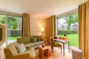 a living room with a couch and a table at Parkhotel Rothof in Munich