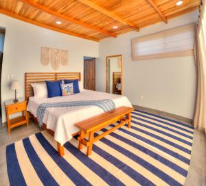 a bedroom with a bed and a bench in it at Casa Ojos Azules, Nosara. New Listing in Nosara