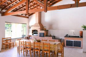 een keuken met een tafel en stoelen en een open haard bij Chacara com churrasq, piscina e lazer - Socorro SP in Socorro