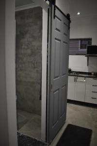 eine Tür in einem Zimmer mit einer Küche im Hintergrund in der Unterkunft Langbeentjie Inn Two Point O in Kapstadt + 10 Fotos