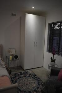 ein Wohnzimmer mit einem weißen Schrank und einem Sofa in der Unterkunft Langbeentjie Inn Two Point O in Kapstadt