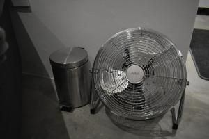 um ventilador de metal sentado ao lado de uma lata de lixo em Langbeentjie Inn Two Point O na Cidade do Cabo