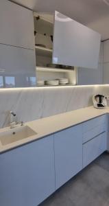 a kitchen with white cabinets and a sink at Luxury Penthouse Apartment in Žďár nad Sázavou