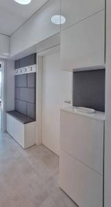 a kitchen with white cabinets and a refrigerator at Luxury Penthouse Apartment in Žďár nad Sázavou
