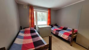 2 łóżka w małym pokoju z oknem w obiekcie Felix- Hostel Pracowniczy w mieście Skierniewice