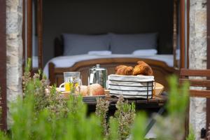 a tray of bread and pastries on a table with a bed at Le Roucadel in Peyreleau