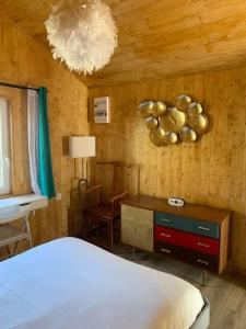 a bedroom with a bed and a table and a desk at chalet paradisiaque en bord de Marne Proche de Disneyland in Isles-lès-Villenoy