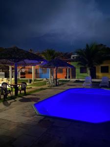 a large blue swimming pool with umbrellas and a patio at POUSADA ESTRELA DA MANHÃ in Barreirinhas