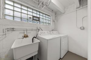 uma lavandaria branca com uma máquina de lavar roupa e um lavatório em Northside FAMLYNEST Lincoln Sq 4BR 2BA 2P Rare find em Chicago