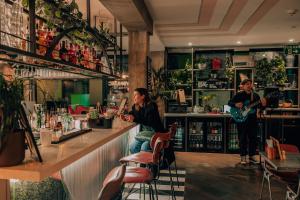 a group of people sitting at a bar playing instruments at The Camden Town Hotel in London +65 photos