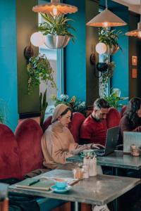 a group of people sitting at a table with a laptop at Selina Camden in London