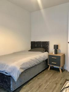 a bedroom with a bed and a night stand at 27 William Jessop Way Bristol BS13 0RL in Whitchurch
