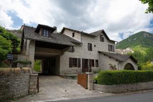 una gran casa de piedra con entrada en Le Roucadel, en Peyreleau