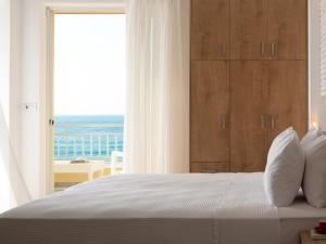 a bedroom with a bed with a view of the ocean at Unique seaside apartment in Rethymno Town