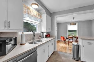 a kitchen with white cabinets and a sink and a table at High Point Terrace Bungalow in Memphis