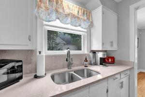 a kitchen with a sink and a window at High Point Terrace Bungalow in Memphis +34 photos