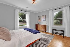 a white bedroom with a bed and two windows at High Point Terrace Bungalow in Memphis