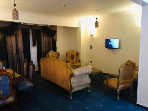 a living room with two chairs and a tv at El Fouad house in Luxor