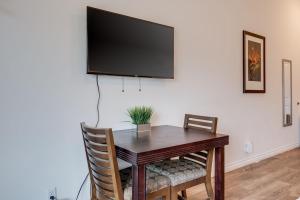 a dining room table with a flat screen tv on a wall at Unit 13 Maui Ohana Studio in Wailuku