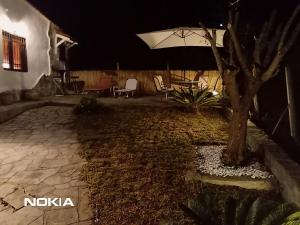 a backyard at night with a table and an umbrella at Alex house with garden in kallithea halkidiki in Kallithea Halkidikis