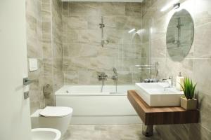 ティミショアラにあるAlternativ 1 Residenceの浴槽、トイレ、洗面台を備えたバスルーム +20枚の写真