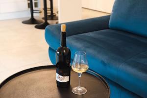 ティミショアラにあるAlternativ 1 Residenceのワイン1本とグラス1杯