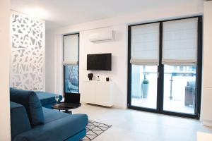 Alternativ 1 Residence في تيميشوارا: غرفة معيشة مع أريكة زرقاء وتلفزيون