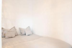 a white bedroom with white pillows on a bed at Alternativ 1 Residence in Timişoara