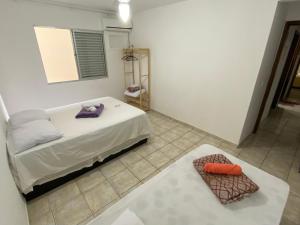 een kleine slaapkamer met een bed en een tapijt bij Dambroso Residence in Balneário Camboriú