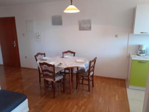 a dining room table and chairs in a kitchen at Apartman Bonaca in Jadranovo