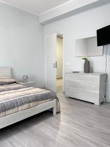 1 dormitorio blanco con 1 cama y vestidor en Le Solite Holiday Rooms, en SantʼEufemia Lamezia