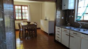 kuchnia ze zlewem i stołem z krzesłami w obiekcie Casa con jardín en la playa de Almieiras w mieście Fene +27 zdjęć